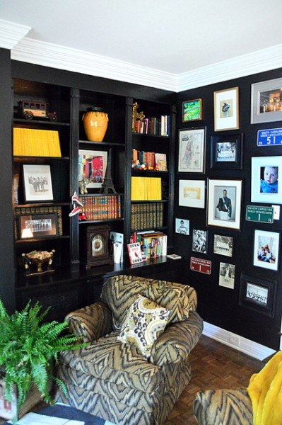 This amazing den painted black & the built ins are awesome full of color